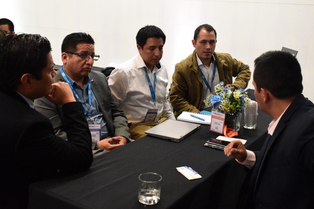 Participantes conversando en mesas de negocio